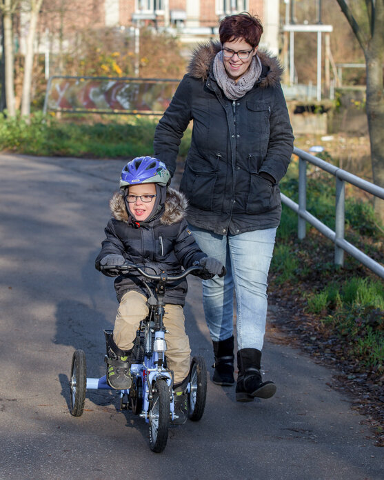 Ein Junge mit Infantile Zerebralparese Orthesen Fährt mit seinem Fahrrad.  | © Pohlig GmbH