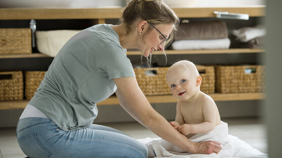 Mutter und Baby knien am Boden | © Ottobock